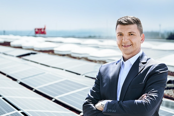 Christian Sokcevic in front of solar panels