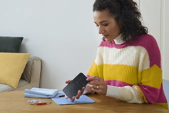 Handydisplay wird am Küchentisch repariert.