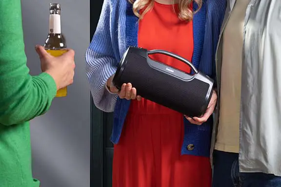 Personen beim feiern, mit einer Partybox in der Hand.