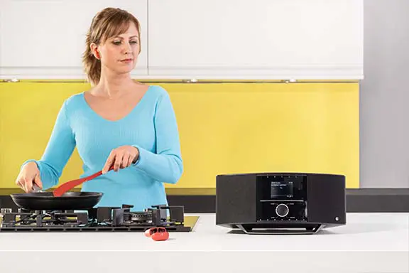 Person hat Bluetooth-Kopfhörer im Ohr und steht bei Radio DIR3210.