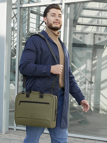 Geschäftsmann trägt die Hama Laptop-Tasche "Ultra Lightweight" über der Schulter auf dem Weg zum nächsten Meeting