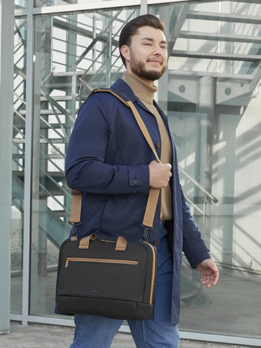 Geschäftsmann trägt die Hama Laptop-Tasche "Ultra Lightweight" über der Schulter auf dem Weg zum nächsten Meeting